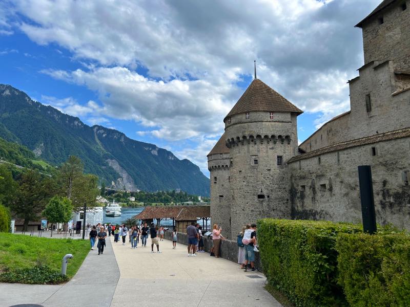 Área externa do Castelo de Chillon em dia de céu azul com nuvens