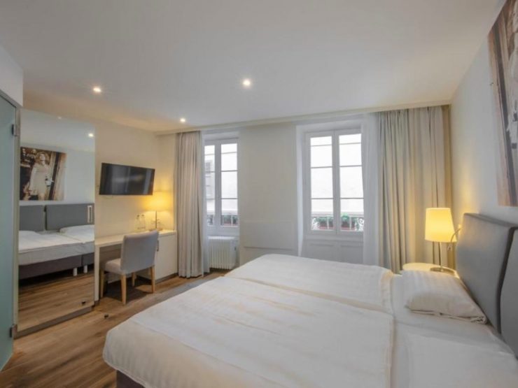 Quarto do La Rouvenaz, dica de onde ficar em Montreux, com cama de casal, TV e espelho