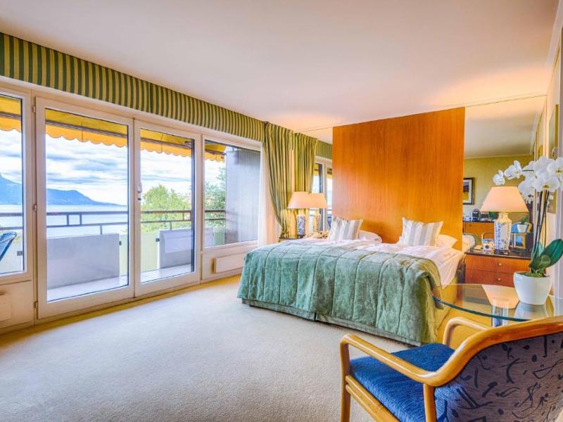 Quarto do Royal Plaza, dica de hotel em Montreux, com cama de casal, carpete e grande varanda