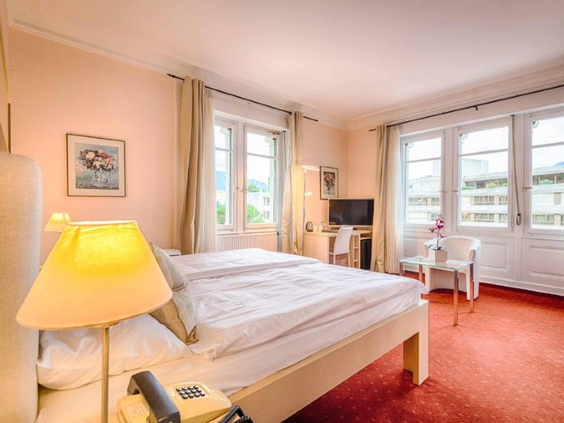 Quarto da Villa Toscane com cama de casal, TV e poltrona