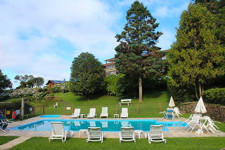 Área verde do Bangalôs da Serra com piscina e espreguiçadeiras (Foto: Esse Mundo é Nosso)