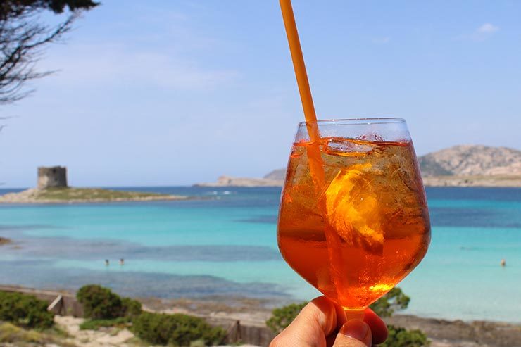 Taça de Aperol de frente pro mar azul