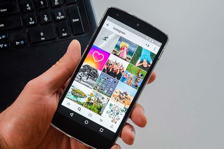 Mão segurando celular com Instagram