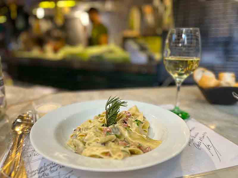 Massa e taça de vinho do Vórtice, dica entre os restaurantes em Buenos Aires, no Mercado de San Telmo