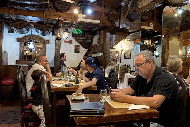Homem sentado em mesa do El Sanjuanino, opção de empanada em Buenos Aires