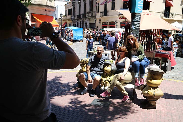 Turistas posam com a estátua da Mafalda em Buenos Aires