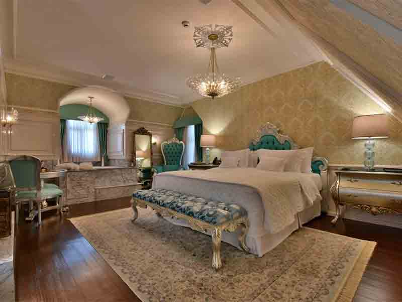 Gramado ou Canela: Quarto do Colline de France com cama de casal, lustre, abajur e tapete