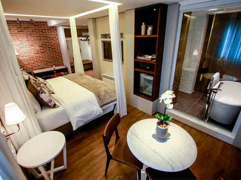 Hotel Cercano, em Gramado, com cama de casal, banheira e mesa de trabalho