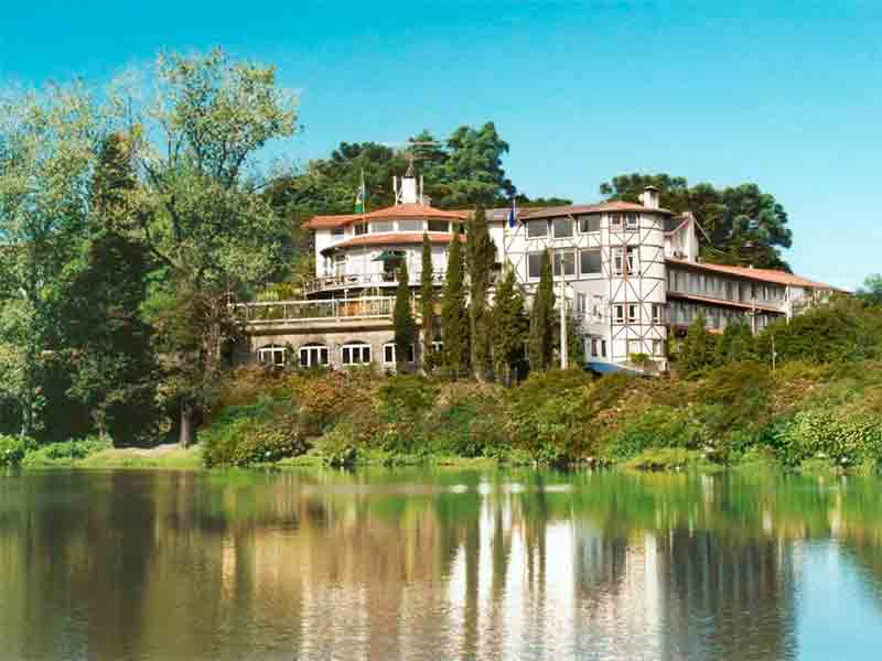 Área externa da Estalagem St. Humbertus com lago e árvores