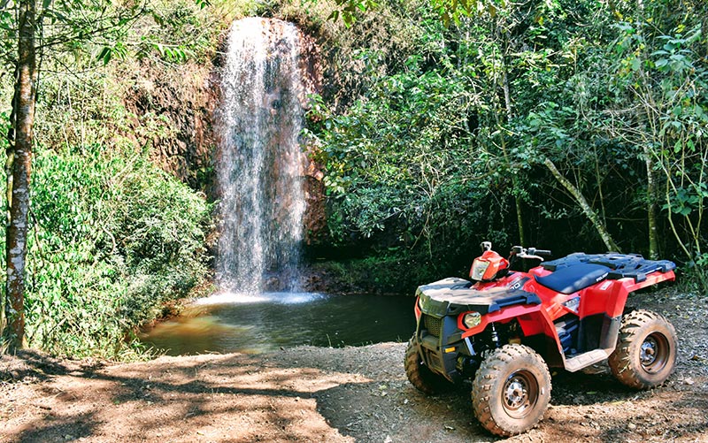 Passeio de quadriciclo em Brotas com cachoeira ao fundo (Foto: Divulgação)