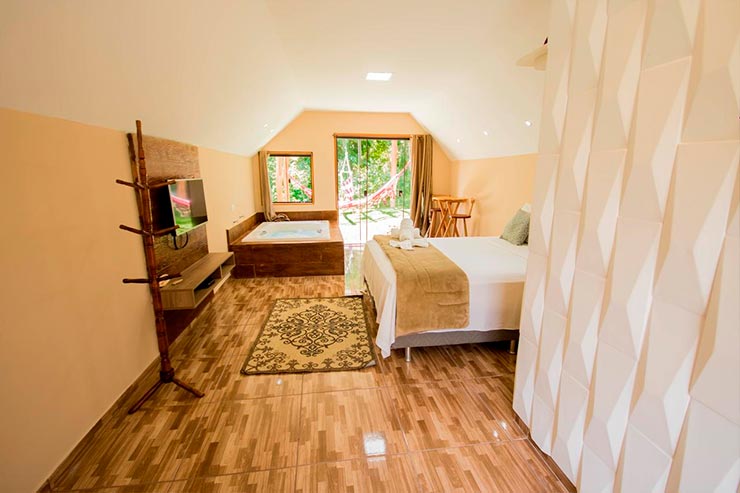 Quarto do Chalé Luiz com banheira de hidromassagem em Santo Antônio do Pinhal (Foto: Reprodução/Booking)