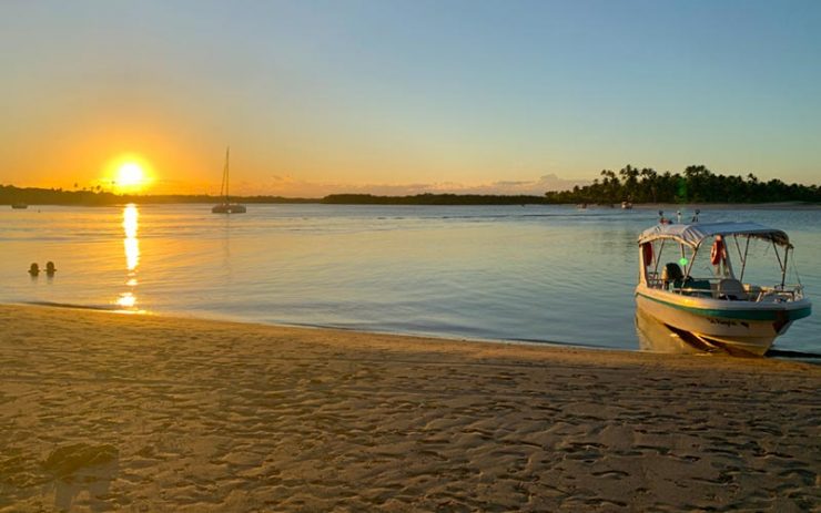 Roteiro em Boipeba: Pôr do sol lindo com um barco na água em Boipeba na praia da Boca da Barra (Foto: Esse Mundo é Nosso)