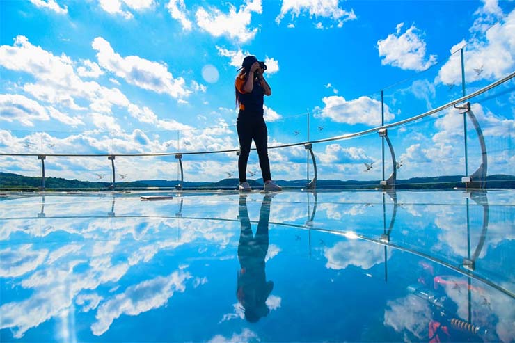 Mulher tirando fotos na plataforma de vidro e aço em Canela