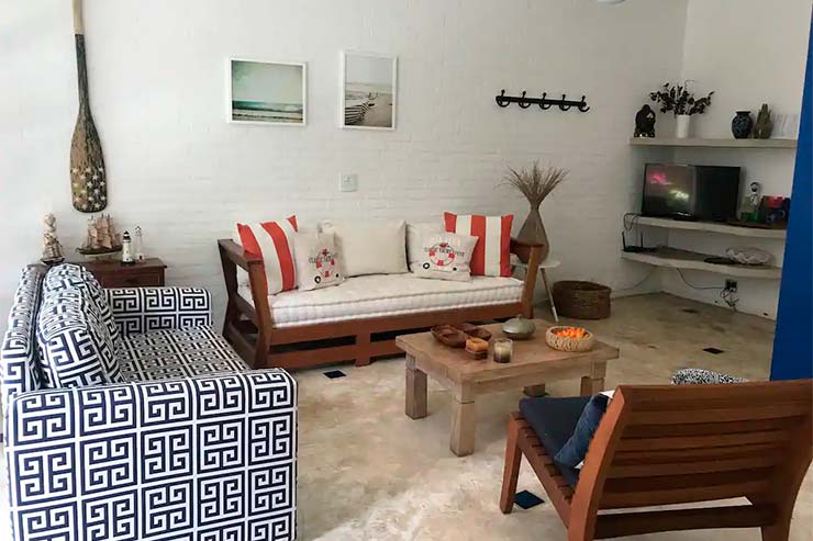 Sala de estar com dois sofás e uma cadeira em Juquehy (Foto: Divulgação)