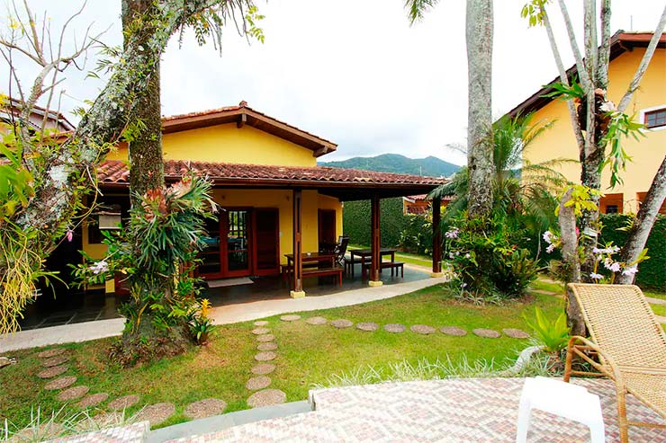 Casa amarela com jardim e espreguiçadeira (Foto: Divulgação)
