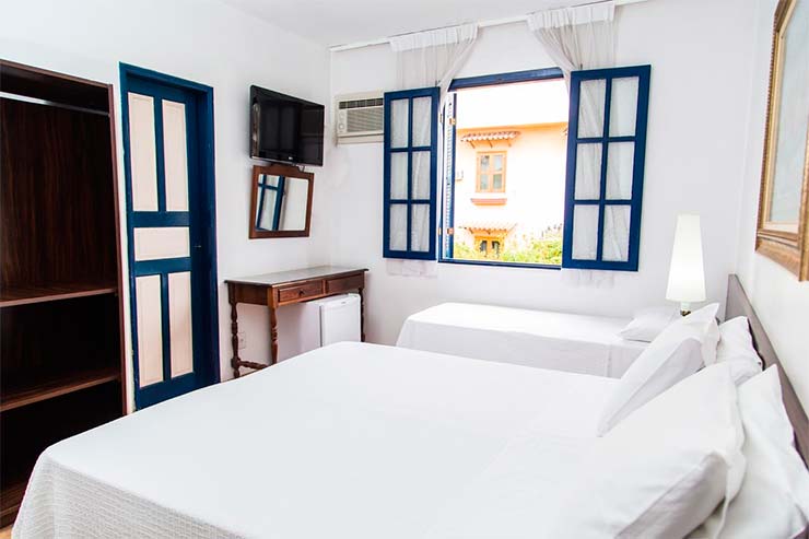 Quarto do Hotel Londres com duas camas e roupas de cama claras (Foto: Divulgação)