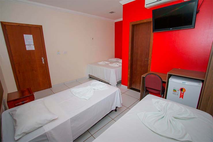 Pousadas em Alter do Chão: Quarto do Hotel Borari com três camas e parede vermelha (Foto: Divulgação)