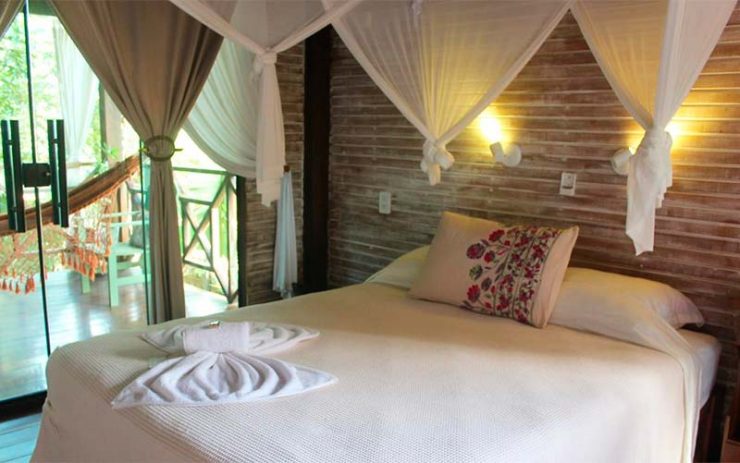 Quarto da pousada Vila Arumã com cama de casal e roupa de cama clara (Foto: Divulgação)