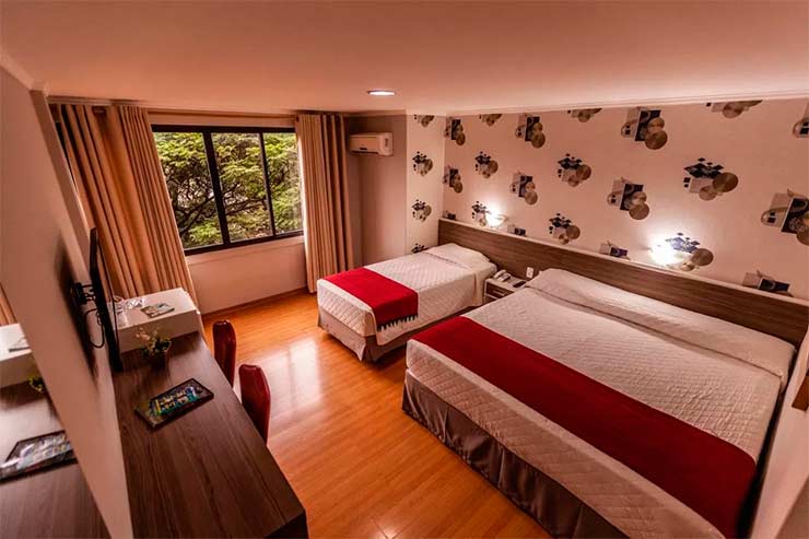 Quarto triplo do Foz Plaza Hotel com TV e mesa de trabalho (Foto: Divulgação)