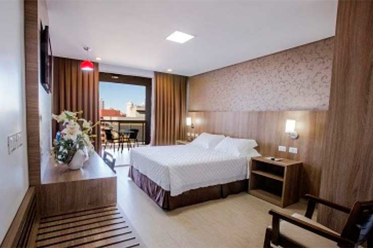 Quarto com cama de casal e paredes em tom bege do Foz President Confort (Foto: Divulgação)