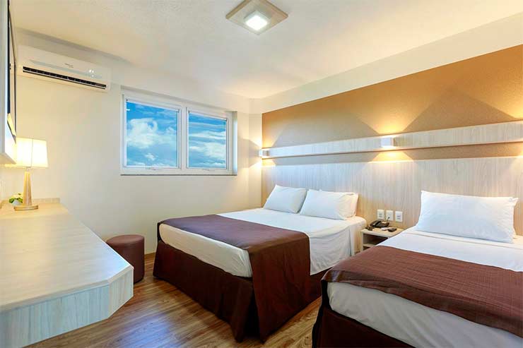 Hotel em Foz do Iguaçu: Quarto triplo do Luz Hotel com duas camas em tons claros (Foto: Divulgação)