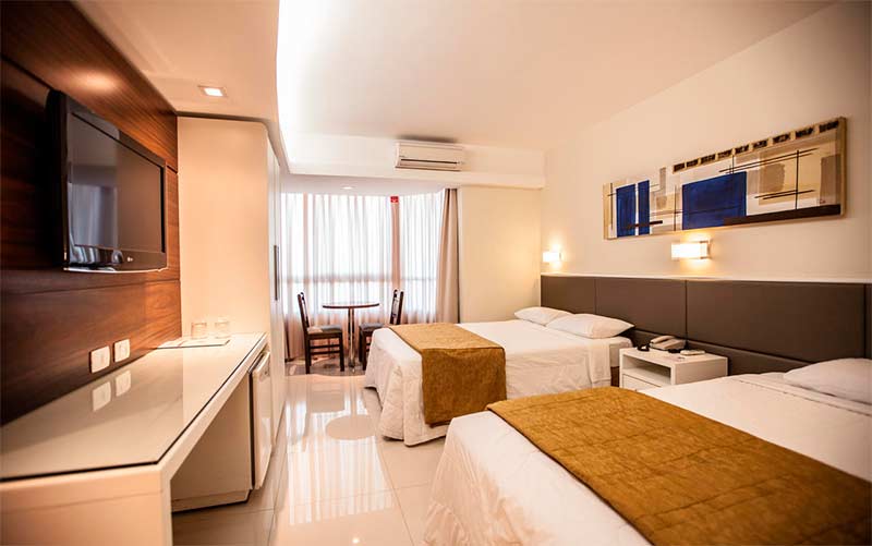 Quarto do Rafain Palace Hotel e Convention com duas camas de casal, TV e mesa de trabalho (Foto: Divulgação)