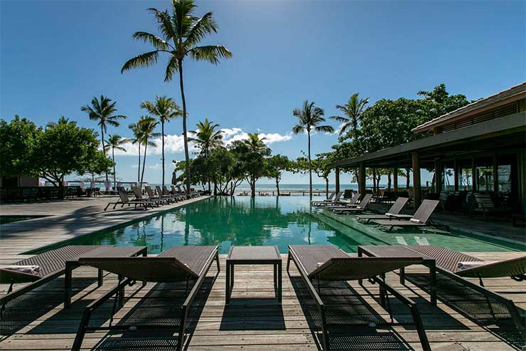 Piscina de borda infinita com espreguiçadeiras e coqueiros do Kûara Hotel (Foto: Divulgação)