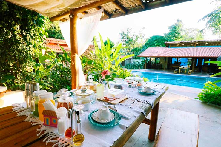 Pousada em Arraial d'Ajuda: Mesa de café da manhã em frente à piscina da Paraíso Ecológico (Foto: Divulgação)