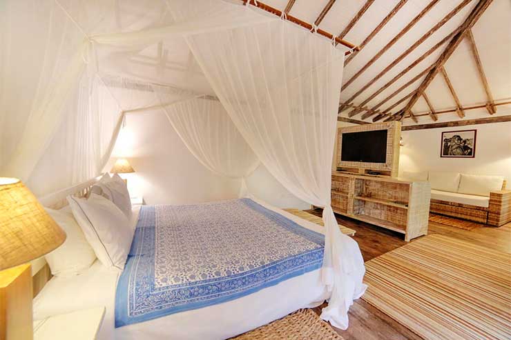 Pousadas em Trancoso: Quarto espaçoso com cama de casal em tons de madeira da Capim Santo (Foto: Divulgação)