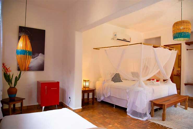 Pousadas em Trancoso: Quarto da Le Refuge com cama de casal e frigobar vintage (Foto: Divulgação)