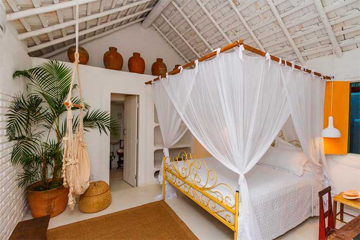 Acomodação da Sol da Manhã com cama de casal e decoração rústica (Foto: Divulgação)