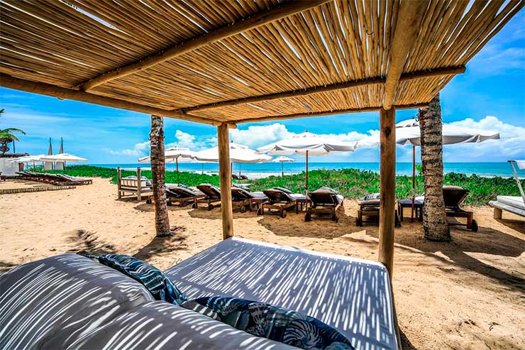 Área da praia da Villas de Trancoso com espreguiçadeiras e guarda-sol (Foto: Divulgação)