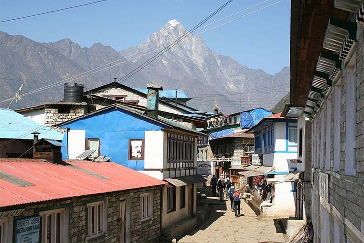 Rua principal de Lukla, Nepal, cerca por montanhas