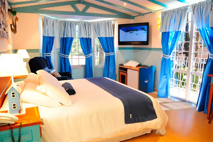 Quarto com cama de casal e tons de azul do Canada Lodge (Foto: Divulgação)