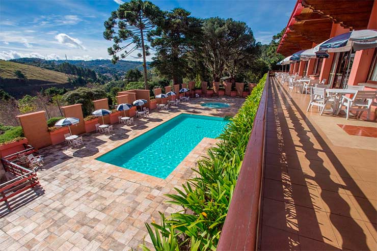 Piscina do Recanto São Cristóvão com mesas e cadeiras e vista da natureza (Foto: Divulgação)