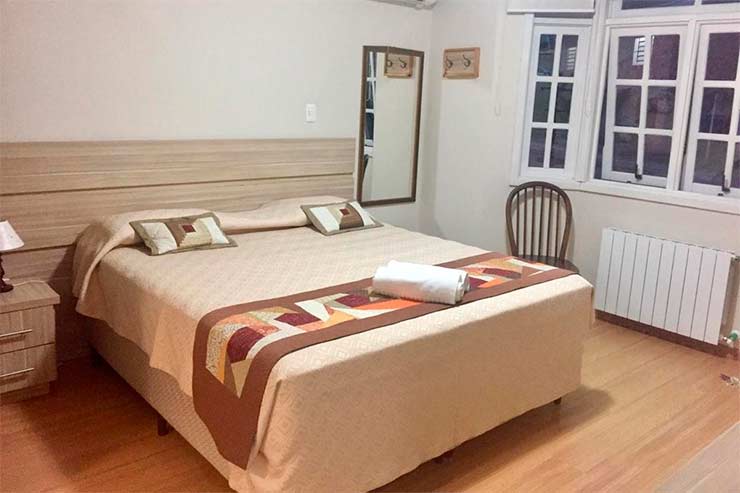 Onde ficar em Canela: Quarto da Carpevita com cama de casal, cadeira e aquecedor (Foto: Divulgação)