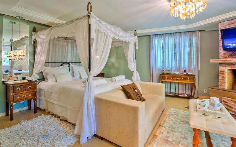 Quarto em estilo clássico com TV, espelho e cama de casal da Pousada Don Ramon (Foto: Divulgação)