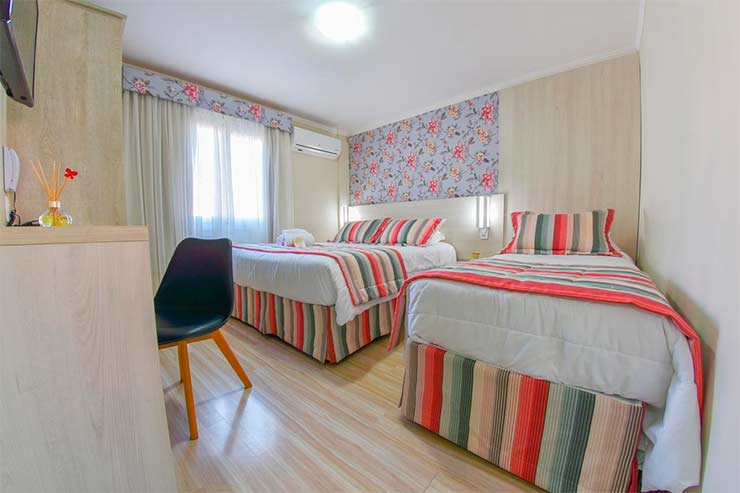 Onde ficar em Gramado: Quarto da Pousada Viena com roupa de cama colorida (Foto: Divulgação)