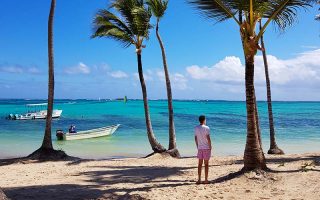 Onde fica Punta Cana? Barco, coqueiros e mar na Playa Bávaro