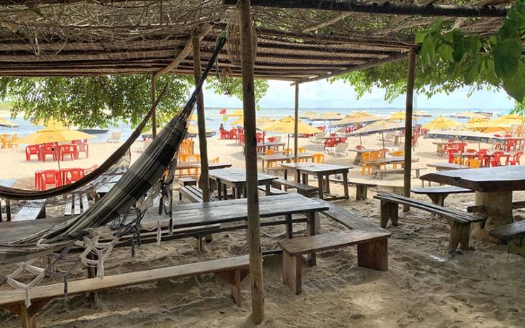 Barraca Toca do Lobo com mesas e redes na praia da Boca da Barra (Foto: Esse Mundo é Nosso)