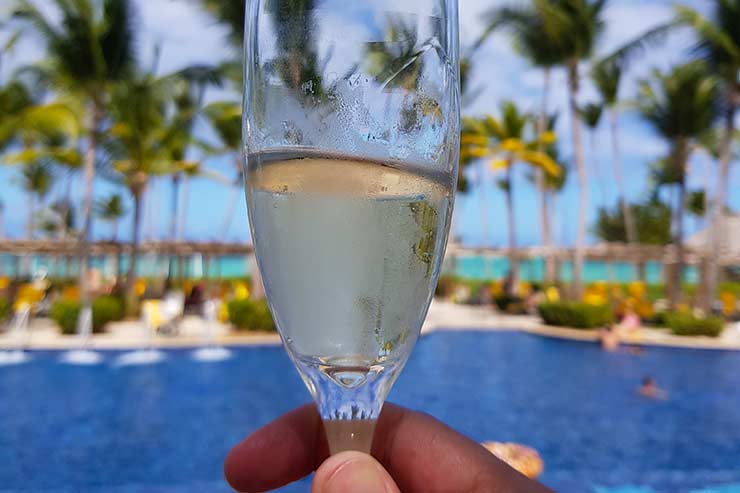 Moeda em Punta Cana: Taça de espumante em frente à piscina do resort