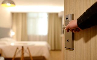 Segredos de uma camareira: mão abrindo porta de quarto de hotel