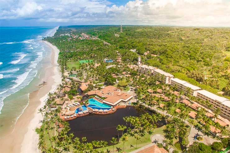 Vista aérea do Cana Brava com acomodações, árvores, piscinas e a praia