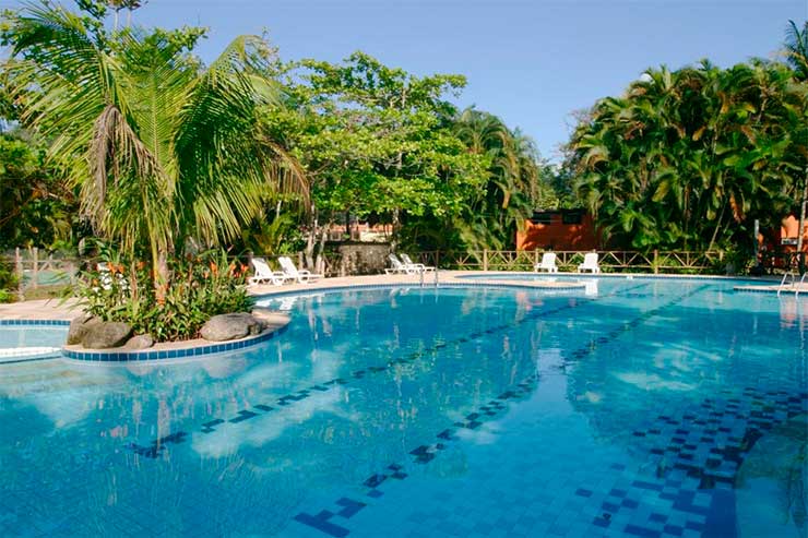 Melhor resort do Brasil: Grande piscina do Itambuca com espreguiçadeiras e árvores em dia de céu azul