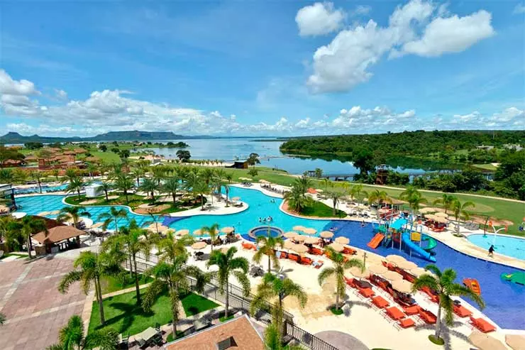 Vista aérea do Malai Manso com piscinas, parque aquático infantil, árvores e rio ao fundo