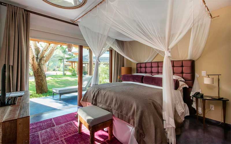 Quarto térreo com cama de casal e janela ampla do Campo Bahia Hotel Villas Spa