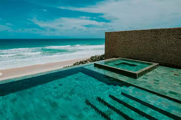 Piscina do Kenoa com borda infinita e vista para o mar em dia de céu azul (Foto: Divulgação)