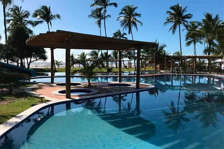Grande piscina do Tororomba com coqueiros em um dia de céu azul