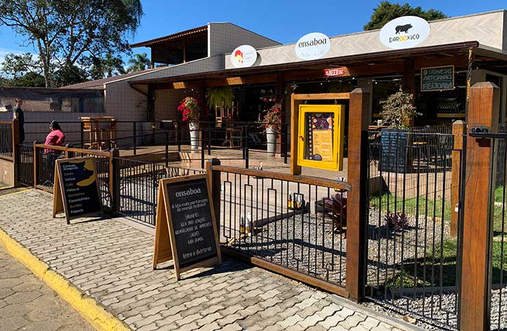 Entrada do Bar do Xico com cardápio na porta e outros estabelecimentos ao lado