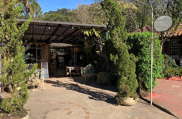 Restaurantes em Visconde de Mauá: Entrada do Bistrô das Meninas com mesas ao ar livre e plantas